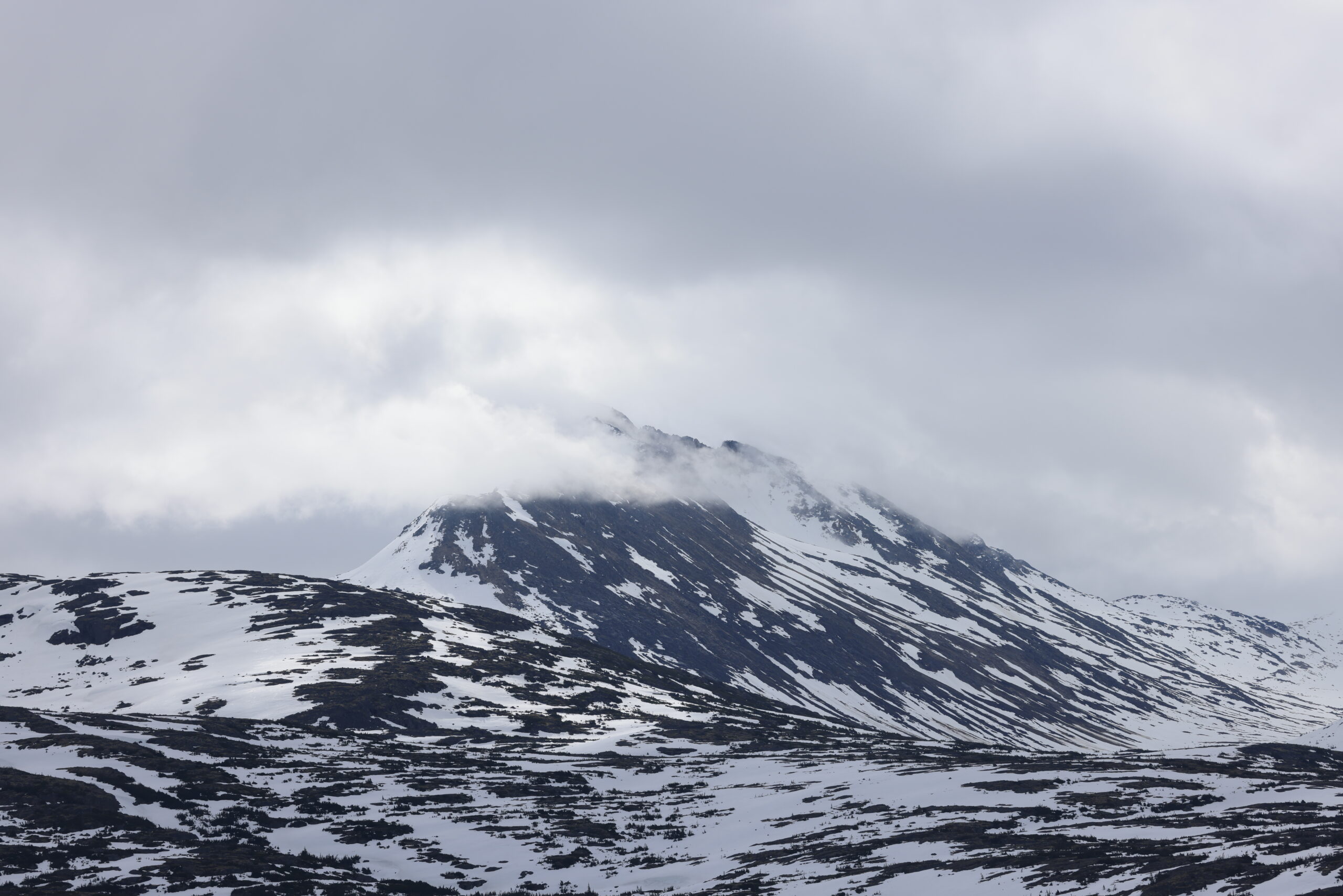 Snow-capped mountain peaks shrouded in clouds