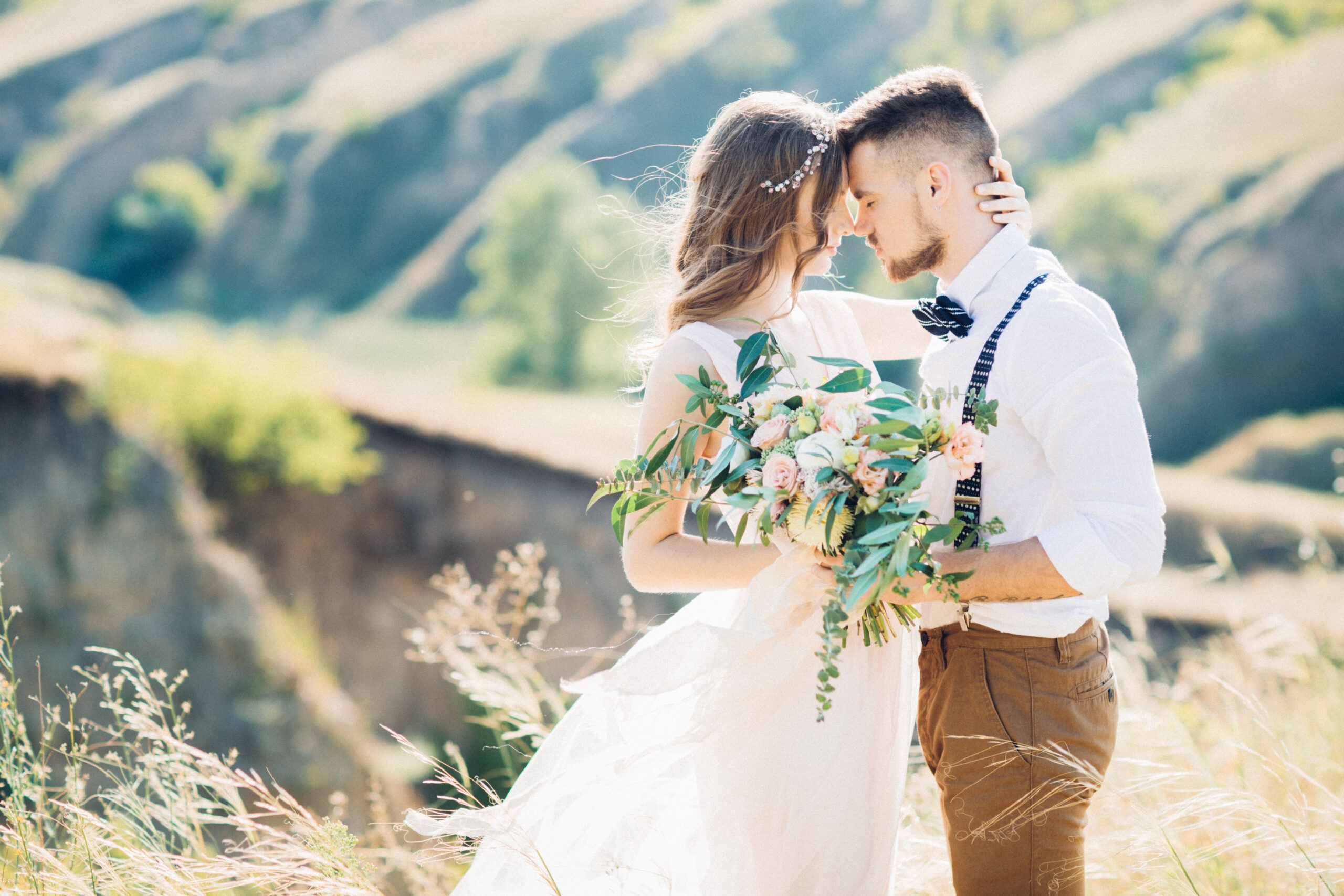 A joyful couple shares an intimate moment in a sunlit field